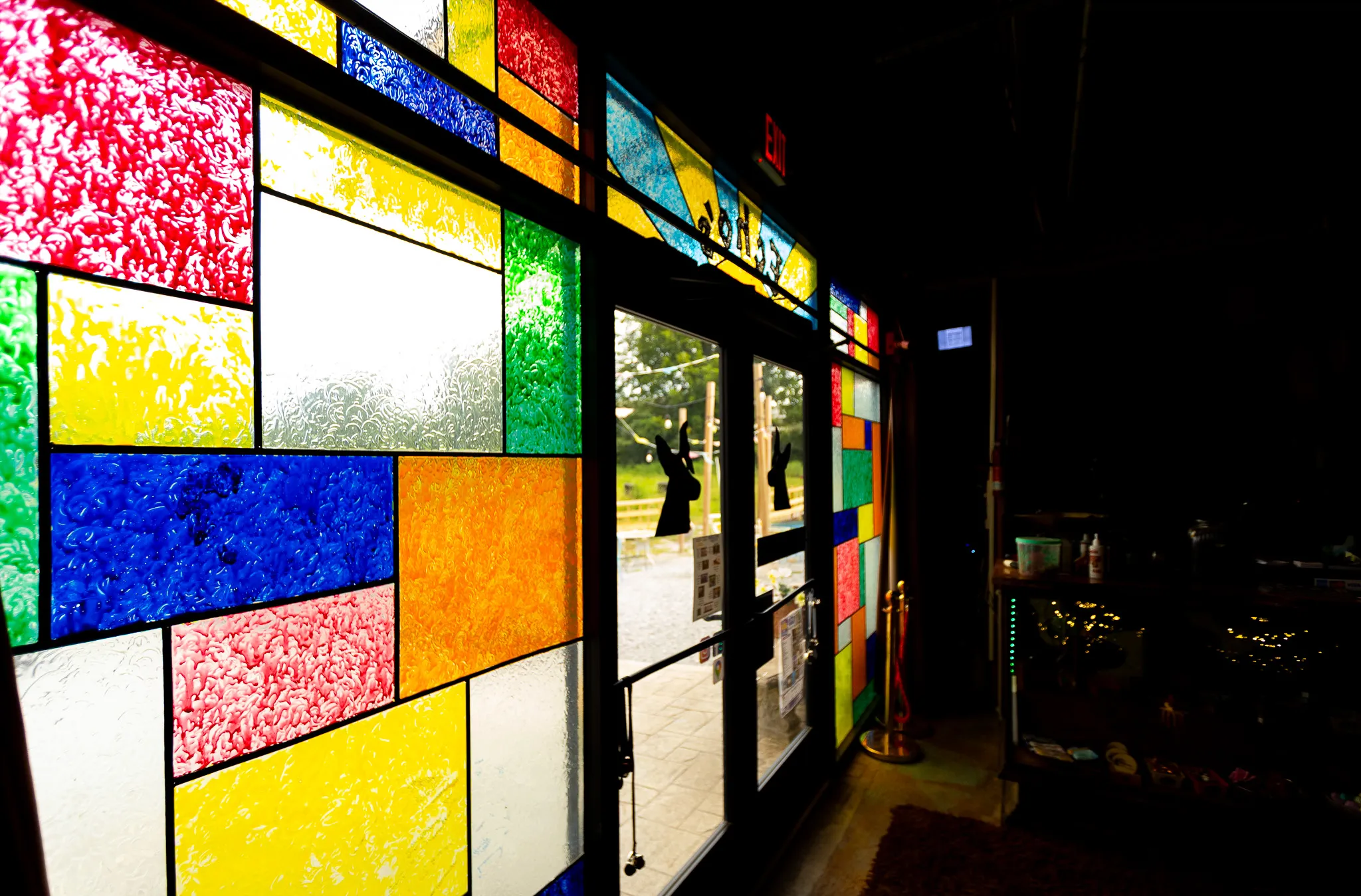 Mondrian-style stained glass at the entrance, with Echo's silhouette on the door